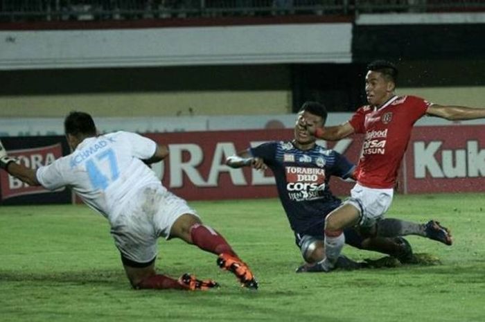 Penyerang Bali United, Alsan Sanda (merah) saat melepaskan sepakan keras ke gawang Arema yang dikawal kiper Achmad Kurniawan di Stadion Kapten I Wayan Dipta, Gianyar, Sabtu (3/12/2016) malam. 
