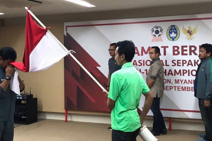 Indra Sjafri mencium bendera Merah Putih jelang keberangkatan Timnas U-19 ke Myanmar.