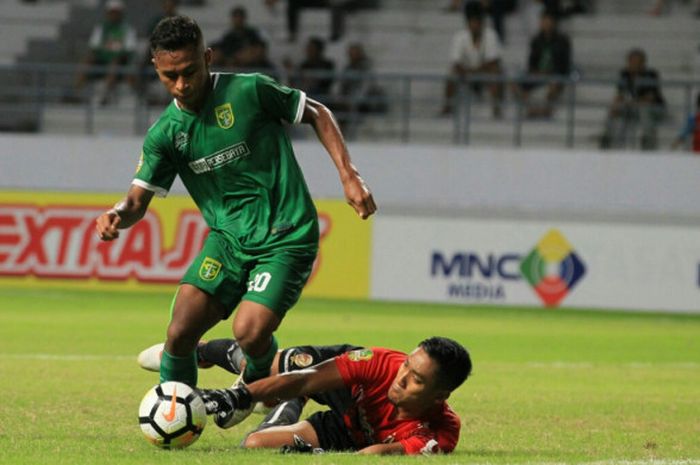  Winger Persebaya, Osvaldo Haay (kiri) merebut bola dari kiper Sriwijaya FC, Sandi Firmansyah pada laga pamungkas Grup B Piala Gubernur Kaltim 2018 di Stadion Batakan, Balikpapan, Rabu (28/2/2018) malam. 