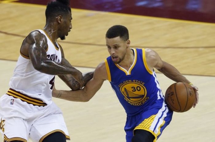 Pemain bintang Golden State Warriors, Stephen Curry (jersey biru) dijaga ketat pemain Cleveland Cavaliers, Iman Shumpert, saat menjalani gim keempat final NBA 2016 di Quicken Loans Arena, Cleveland, Ohio, Jumat 910/6/2016) malam waktu setempat atau Sabtu pagi WIB. Pada gim ini, Warriors menang 108-97 atas Cavaliers dan memimpin seri final 3-1.