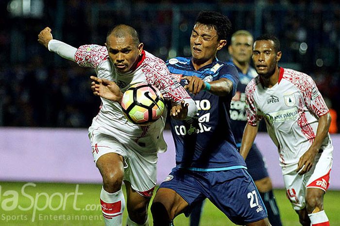 Striker Arema FC, Dedik Setiawan (kanan), berebut bola dengan bek Persipura Jayapura, Ricardo Salampessy, dalam laga pekan ke-15 Liga 1 di Stadion Kanjuruhan Kabupaten Malang, Jawa Timur, Minggu (16/07/2017) malam.
