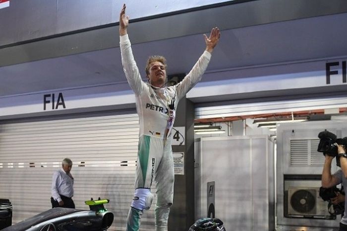 Pebalap Mercedes, Nico Rosberg, melakukan selebrasi setelah finis di urutan pertama pada GP Singapura yang berlangsung di Sirkuit Marina Bay Street, Minggu (18/9/2016).