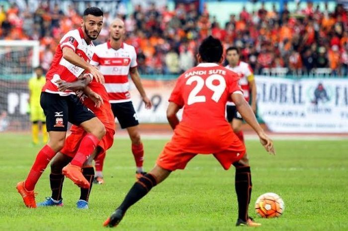 Gelandang Madura United, Reduane Zerzouri (kiri) dikawal ketat pemain Persija pada laga perdana Cilacap Cup 2017 di Stadion Wijayakusuma, Jumat (24/3/2017) sore. 