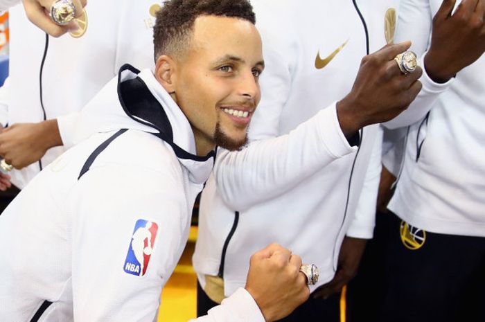Pebasket bintang Golden State Warriors, Stephen Curry, memamerkan cincin juara NBA 2016-2017 yang diberikan sebelum laga melawan Houston Rockets di Oracle Arena, Oakland, California, Amerika Serikat, Selasa (17/10/2017).