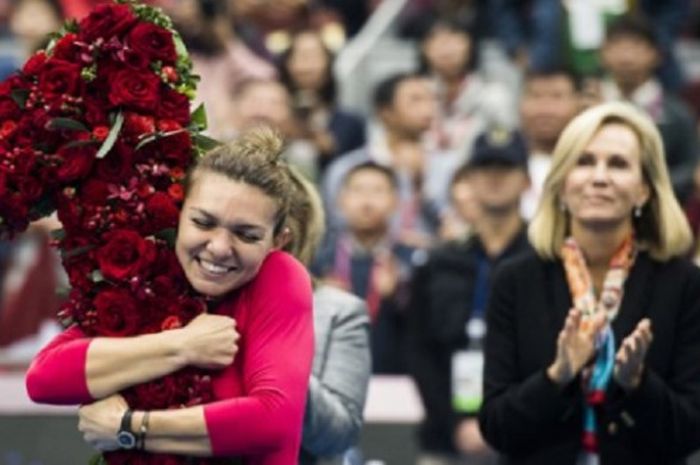 Simona Halep (kiri) merayakan keberhasilannya menjadi petenis nomor wahid dunia dengan memeluk buket berbentuk angka 1, Sabtu (7/10/2017).