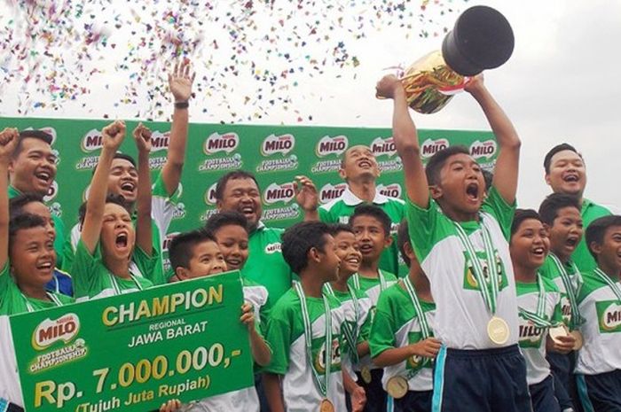 Pemain SD Al Ma’soem Sumedang mengangkat trofi kejuaraan usai memenangi laga final kompetisi  MILO Football Championship di Stadion Siliwangi, Bandung, Minggu (26/3/2017).