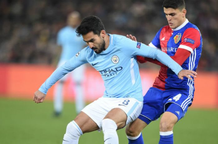  Gelandang Manchester City, Ilkay Guendogan sedang berduel dengan bek FC Basel, Taulant Xhaka pada laga leg pertama babak 16 besar Liga Champions, Selasa (13/2/2018) waktu setempat. 