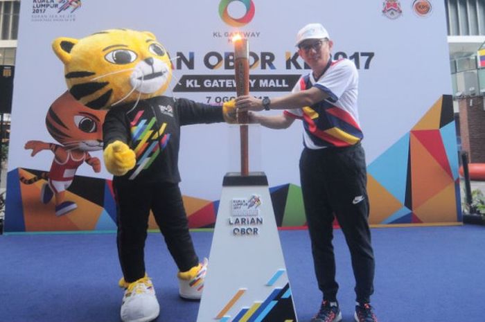 Maskot SEA Games Kuala Lumpur 2017, Rimau, berpose dengan salah satu pelari untuk kegiatan larian obor atau run torch di Kuala Lumpur, Malaysia, Senin (7/8/2017).