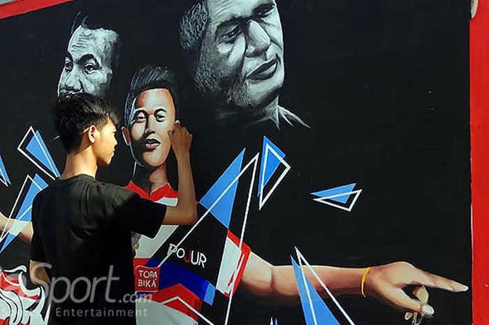 Salah seorang peserta memamerkan keahliannya dalam membuat mural pada lomba mural yang digelar di kompleks kantor baru Madura United di Pamekasan, lomba berakhir pada Kamis (20/9/2018).