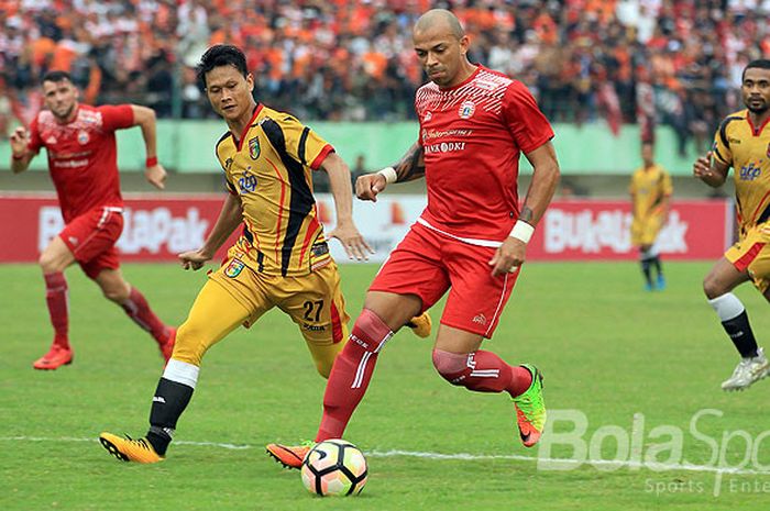  Aksi Striker Persija Jakarta, Ivan Carlos, saat menggiring bola dibayangi bek Mitra Kukar, Dedi Gus