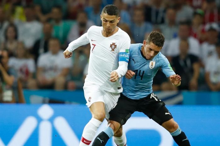 Gelandang Uruguay, Lucas Torreira (kanan), berduel dengan megabintang Portugal, Cristiano Ronaldo, dalam laga babak 16 besar Piala Dunia 2018 di Stadion Fisht, Sochi, Rusia pada 30 Juni 2018.