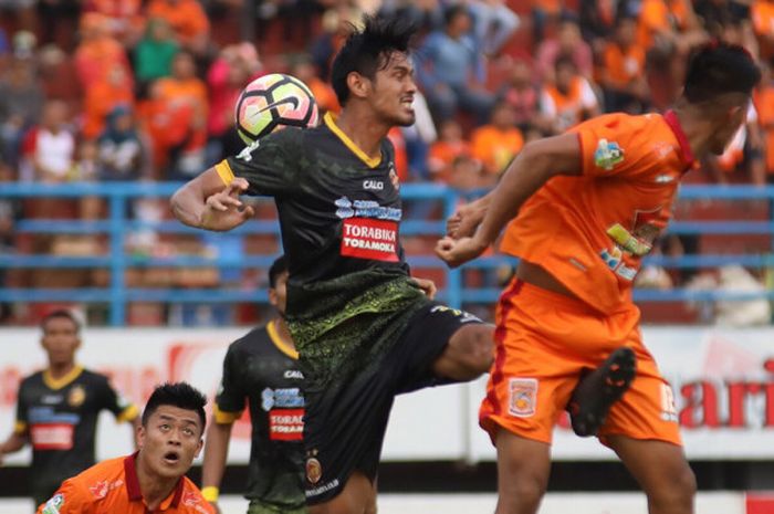 Pemain Borneo FC, Lerby Aliandry saat berduel udara dengan pemain Sriwijaya FC. Sabtu (5/8/2017).