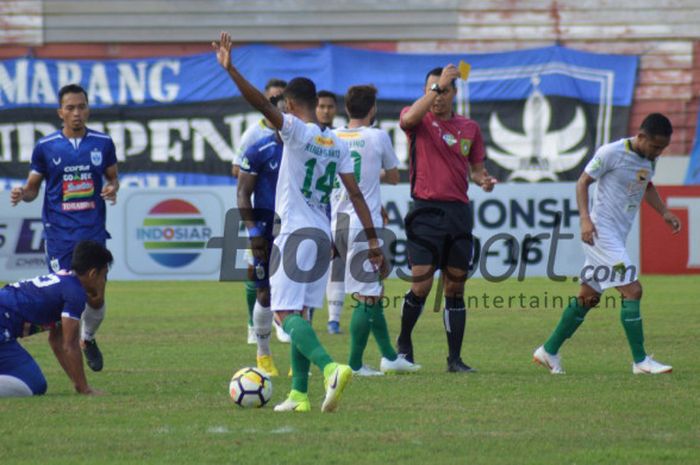 Wasit asal Daerah Istimewa Yogyakarta, Fariq Hitaba saat memberikan kartu kuning pada laga PSIS Semarang kontra Persebaya Surabaya di Stadion Moch Soebroto, Magelang, Minggu (22/7/2018).