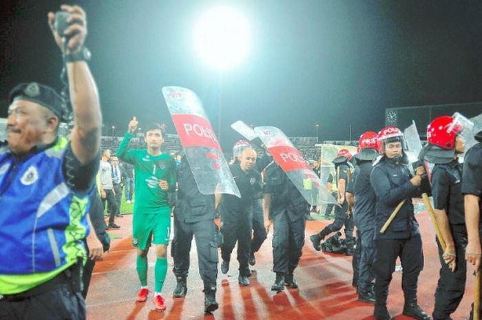 Pasukan Anti Rusuhan Awam (PORU) mengiringi penjaga gol JDT, Mohd Izham Tarmizi keluar dari kawasan stadion.
