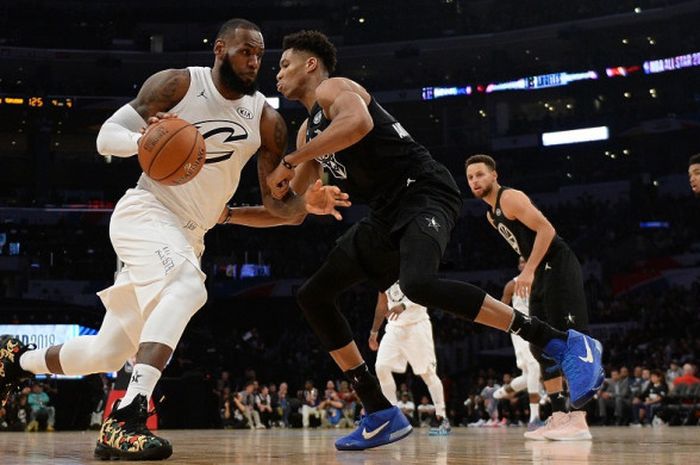 Pebasket bintang Cleveland Cavaliers yang memimpin Tim LeBron, LeBron James, berupaya melewati penjagaan Giannis Antetokounmpo dari Tim Stephen pada laga NBA All Star 2018 yang berlangsung di Staples Center, Los Angeles, California, Amerika Serikat (AS), Minggu (18/2/2018) malam waktu setempat atau Senin pagi WIB.