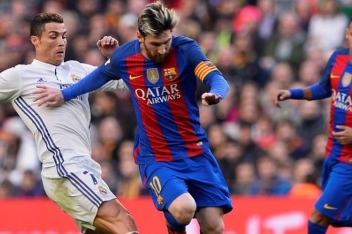  Penyerang Real Madrid, Cristiano Ronaldo (kiri), mencoba menghentikan pergerakan Lionel Messi dari FC Barcelona dalam laga el clasico di Stadion Camp Nou, Barcelona, Spanyol, 3 Desember 2016. 