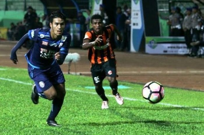 Gelandang Arema FC, Muhammad Rafli (kiri) melepaskan diri dari kejaran bek Perseru Serui, Kalvin Wopi, pada pekan ke-10 Liga 1 musim 2017 di Stadion Gajayana, Kota Malang, Sabtu (10/6/2017) malam.
