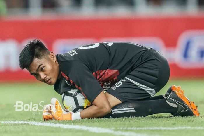 Kiper Arema FC, Kurniawan Kartika Aji, mengamankan bola pada laga Liga 1 2018 kontra Persija Jakarta di Stadion Utama GBK pada Sabtu (31/3/2018).