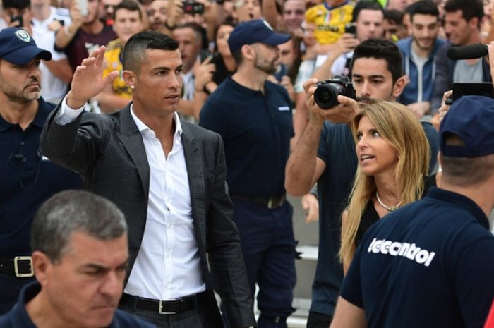 Pemain baru Juventus, Cristiano Ronaldo, melambaikan tangan kepada para suporter saat tiba untuk melakukan tes medis di markas klub di Stadion Allianz, Turin, Senin (16/7/2018).