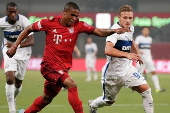 Gelandang Bayern Muenchen, Douglas Costa (kiri), berebut bola dengan Federico Di Marco (Internazionale) dalam laga uji coba di Shanghai Stadium pada 21 Juli 2015.