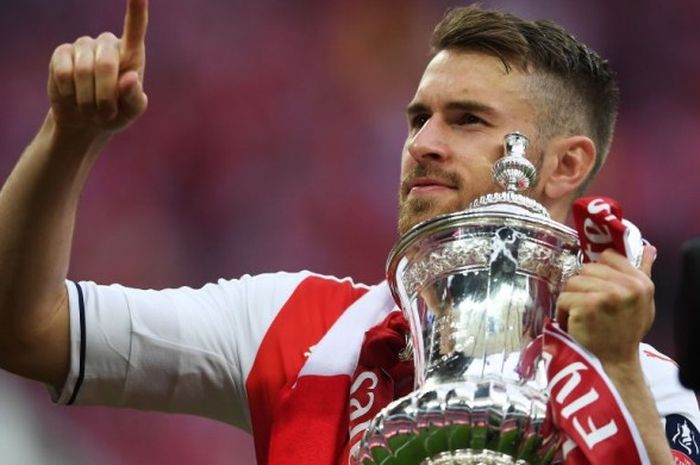 Gelandang Arsenal, Aaron Ramsey, mengangkat trofi Piala FA seusai mengalahkan Chelsea dalam laga di Stadion Wembley, Sabtu (27/5/2017)