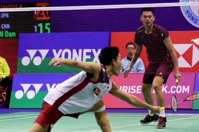 Pebulu tangkis tunggal putra Jepang, Kento Momota (jersey putih) mengembalikan kok ke arah Lin Dan pada babak pertama Hong Kong Open 2018 yang berlangsung di Hong Kong Coliseum, Rabu (14/11/2018).