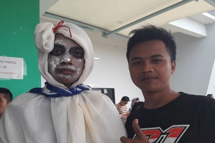 Fauzi (kiri) mengenakan kostum pocong saat akan menontong pertandingan Persib VS Sriwijaya, Selasa (16/1/2018). 