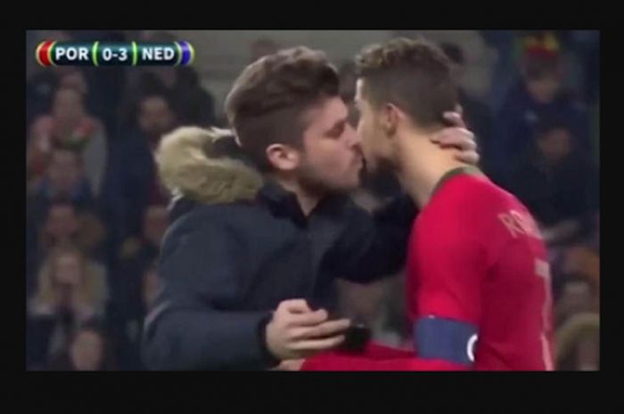 Seorang fans yang masuk ke lapangan dalam pertandingan persahabatan Portugal dan Belanda (26/3/2018), nyaris mencium Cristiano Ronaldo.