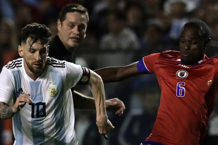 Penyerang Argentina, Lionel Messi, melewati pemain Haiti, Waldo Vernet, dalam pertandingan uji coba, Selasa (29/5/2018) di Stadion La Bombonera, Buenos Aires.