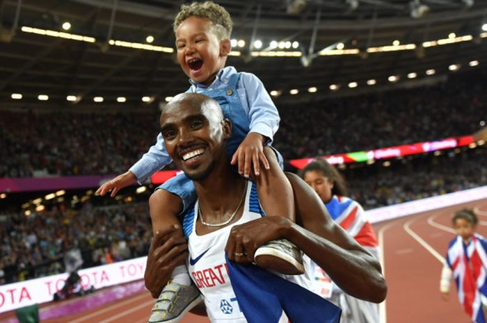 Pelari jarak menengah Inggris, Mohamed Farah (Mo Farah), menggendong anak laki-lakinya seusai memenangi lomba lari nomor 10.000 meter pada Kejuaraan Dunia Atletik yang berlangsung di London Stadium, London, Inggris, Jumat (4/8/2017).