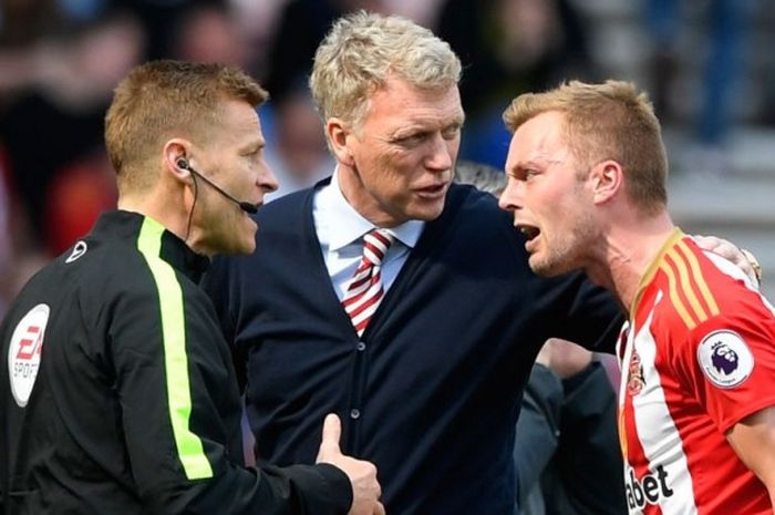 Manajer Sunderland, David Moyes (tengah), mencoba menenangkan pemainnya, Sebastian Larsson (kanan), yang melakukan protes kepada asisten wasit, Mike Jones, dalam laga Premier League kontra Manchester United di Stadium of Light, Sunderland, Inggris, pada 9 April 2017.