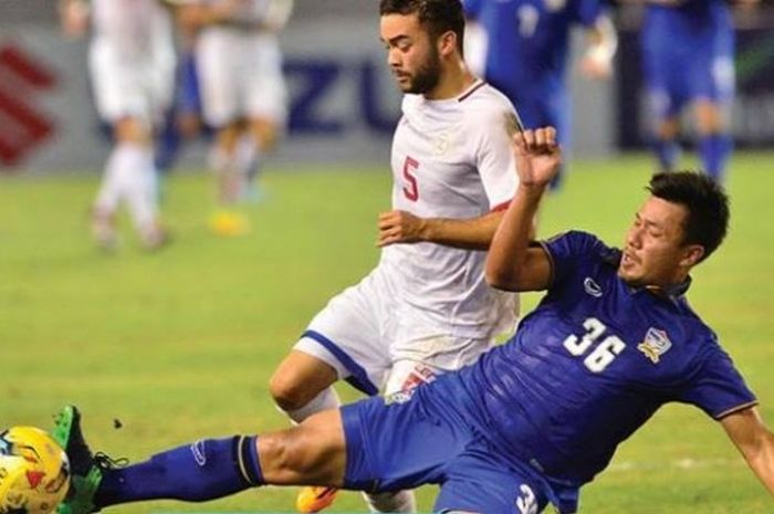 Pemain Thailand, Prakit Deprom (biru) berebut bola dengan gelandang Filipina, Mike Ott di Philipinne