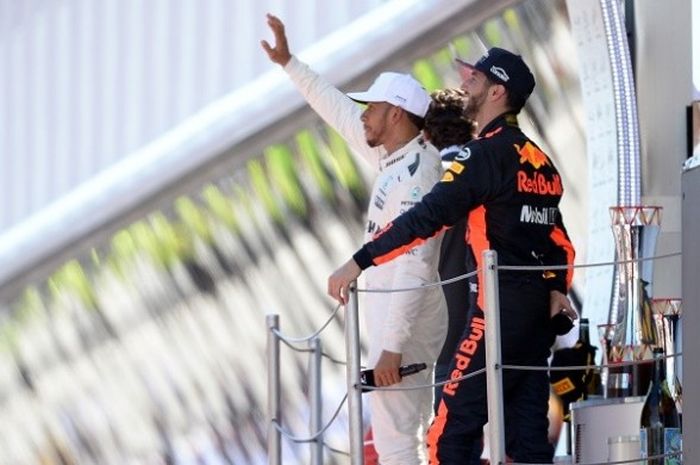 Pebalap Mercedes, Lewis Hamilton (baju putih) melambaikan tangan ke arah penonton setelah finis di urutan pertama pada GP Spanyol yang berlangsung di Circuit de Barcelona-Catalunya, Minggu (14/5/2017).