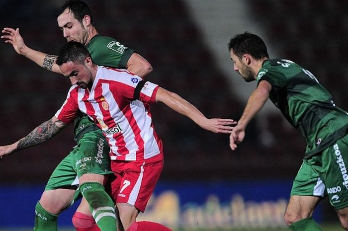 Pemain Girona FC, Ricardo Alvarez (tengah), mempertahankan bola dari incaran pemain Eibar dalam pertandingan Segunda Division Spanyol di Estadia Montilivi, Girona, Spanyol, pada 25 Januari 2014.