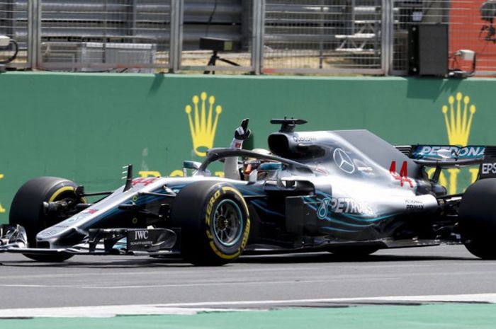 Lewis Hamilton (Mercedes) menyapa penggemarnya saat melintasi Sirkuit Silverstone dalam sesi kualifikasi F1 GP Inggris 2018, Sabtu (8/7/2018).