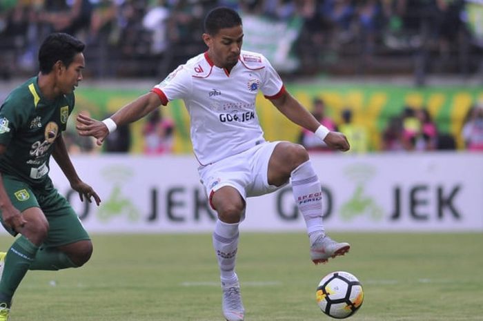 Aksi gelandang Persija Jakarta, Renan Silva, coba dihentikan oleh pemain Persebaya, Misbakus Solikin