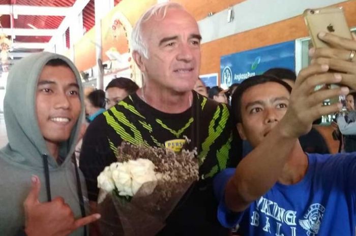 Pelatih Persib Bandung, Mario Gomez (tengah) disambut dan diajak berswafoto oleh bobotoh ketika tiba di Bandara Internasional I Gusti Ngurah Rai, Denpasar, Bali, Selasa (16/10/2018) sore.