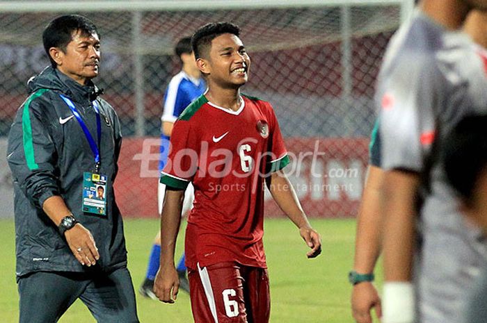 Gelandang timnas U-19 Indonesia, Muhamad Rafi Syarahil (tengah) bersama pelatih Indra Sjafri (kiri) berjalan meninggalkan lapangan usai laga melawan Singapura pada pertandingan Grup A Piala AFF U-19 2018 di Stadion Gelora Delta Sidoarjo, Jawa Timur, Selasa (03/07/2018) malam.