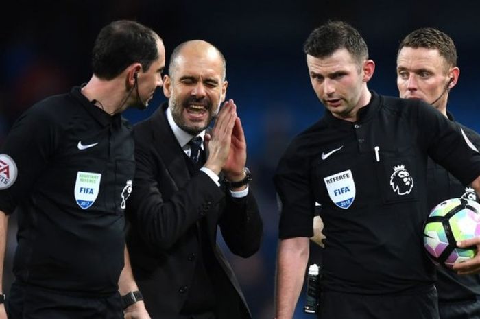 Ekspresi Manajer Manchester City, Pep Guardiola (kedua dari kiri), saat berbicara dengan wasit dalam laga kontra Liverpool FC di Etihad Stadium, Minggu (19/3/2017).