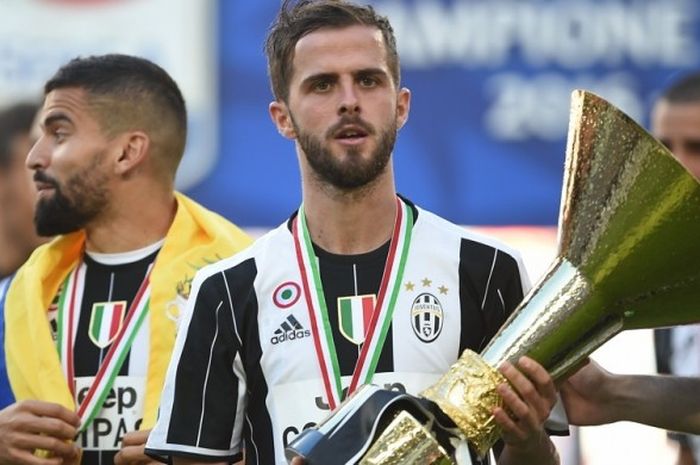 Gelandang Juventus, Miralem Pjanic, berpose bersama trofi Liga Italia 2016-2017 setelah tim memastikan menjadi juara seusai mengalahkan Crotone 3-0 di Juventus Stadium, Turin, Italia, pada Minggu (21/5/2017).