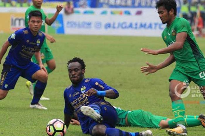 Gelandang Persib, Michael Essien (tengah) terjatuh saat melindungi bola dari penyerang Bhayangkara FC, Ilham Udin Armayn (kanan) pada laga Liga 1 musim 2017 di Stadion Si Jalak Harupat, Kabupaten Bandung, 24 September 2017. 