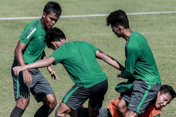 Gelandang muda Sriwijaya FC, Syahrian Abimanyu (rompi oranye), terjatuh saat dihadang Muhammad Luthfi dkk dalam latihan simulasi pertandingan timnas U-19 Indonesia di Lapangan B, kompleks Gelora Bung Karno (GBK), Senayan, Jakarta Pusat, Rabu (21/2/2018)