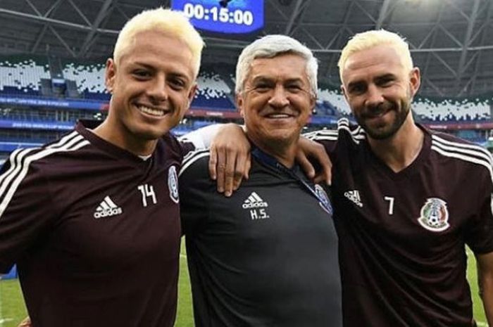 Duo pemain timnas Meksiko, Javier Hernandez (kiri) dan Miguel Layun mengapit asisten pelatih Humberto Sierra dengan rambut pirang jelang laga kontra Brasil pada 16 besar Piala Dunia 2018, 2 Juli 2018. 