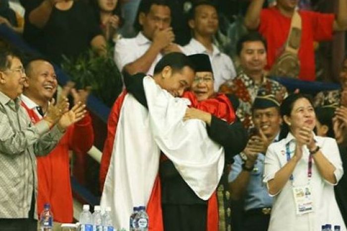  Pesilat Indonesia Hanifan Yudha Kusumah memeluk Joko Widodo dan Prabowo Subianto usai memastikan diri meraih medali emas pada cabor pencak silat Asian Games 2018, Rabu (29/8/2018). 