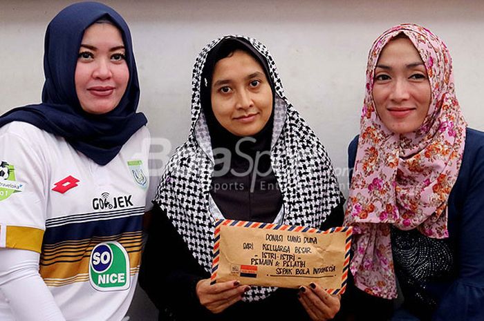 Istri Aji Santoso, Rini Sofia (kiri) saat memberikan donasi dari kumpulan istri pemain dan pelatih sepakbola Indonesia kepada Istri Almarhum Choirul Huda, Lidya (tengah) di rumahnya (22/10/2017) Minggu siang.