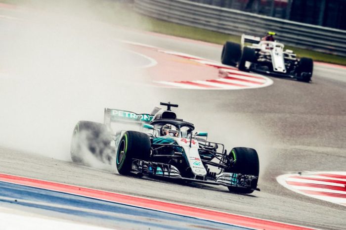 Aksi Lewis Hamilton (depan) saat melintas di bawah guyuran hujan yang membasahi lintasan Circuit of The Americas pada sesi FP2 F1 GP Amerika Serikat, Sabtu (20/10/2018) dini hari WIB.