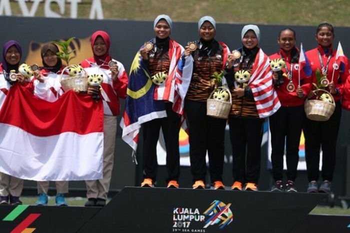 Tim panahan putri Indonesia (paling kiri) berpose di podium setelah mendapat medali perak dari nomor beregu recurve di Turf Field National Sports Council, KL Sport City, Senin (21/8/2017).