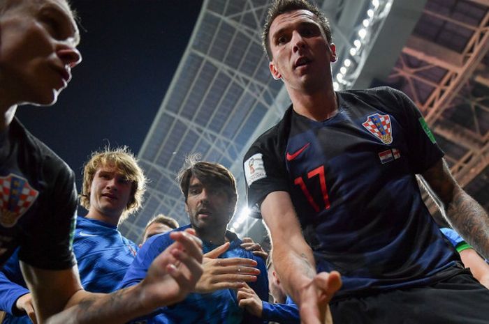  Salah satu foto hasil jepretan fotografer AFP, Yuri Cortez, saat dia dibantu bangun oleh striker Kroasia, Mario Mandzukic, setelah jatuh tertimpa para pemain yang merayakan gol dalam laga semifinal Piala Dunia 2018 melawan Inggris, Rabu (11/7/2018) di Luzhniki Stadium, Moskow. 