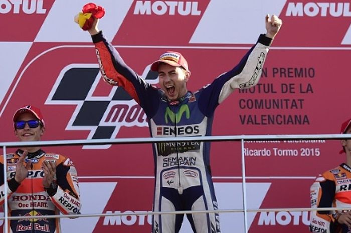 Pebalap Movistar Yamaha, Jorge Lorenzo (tengah), merayakan keberhasilan mencatatkan waktu tercepat pada sesi kualifikasi GP Valencia, Sabtu (7/11/2015).
