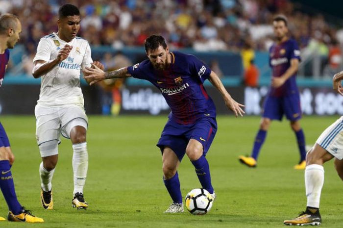 Lionel Messi mencoba melewati penjagaan pemain Real Madrid pada pertandingan ICC 2017 di Miami, Sabtu (26/7/2017). 